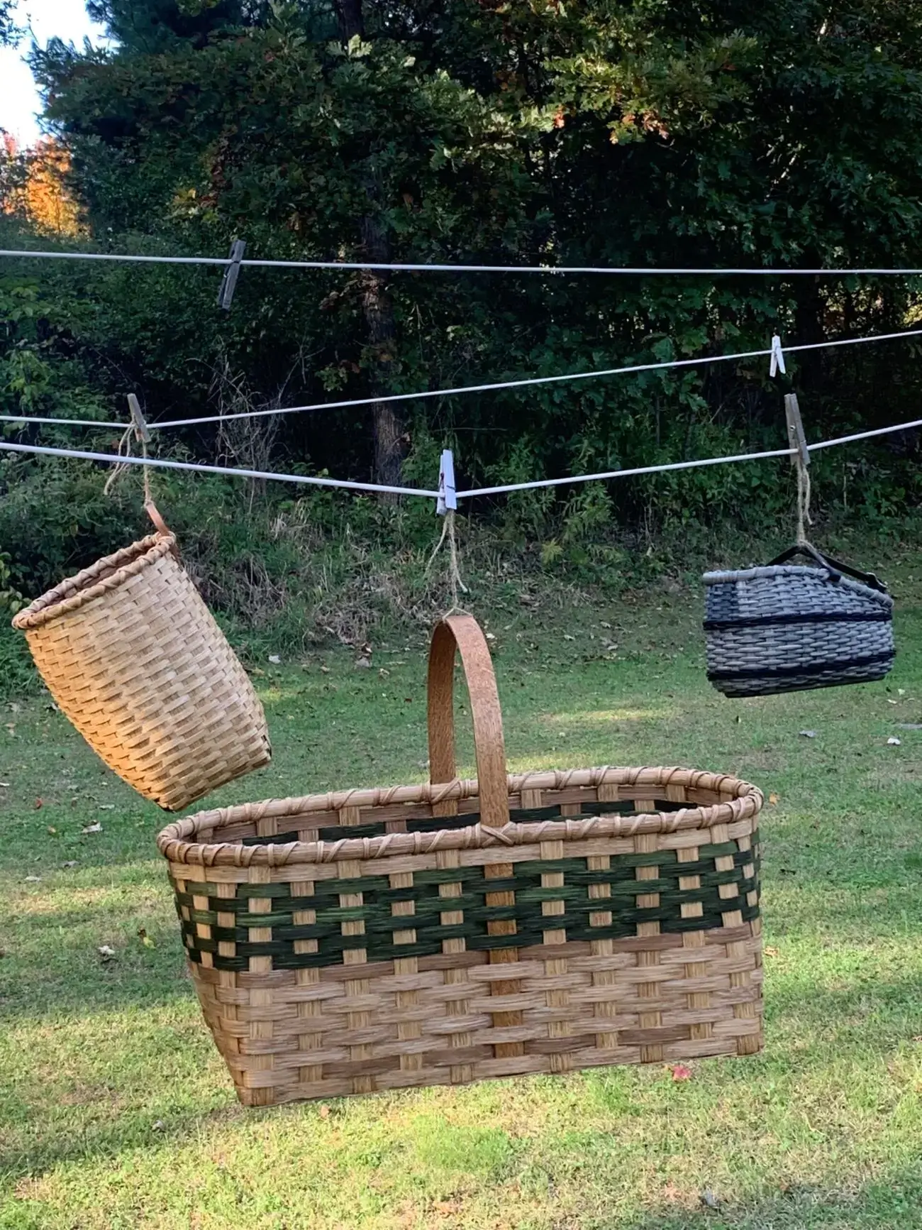 Three handmade baskets hanging on a clothesline