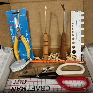 The box contains several tools for basket weaving
