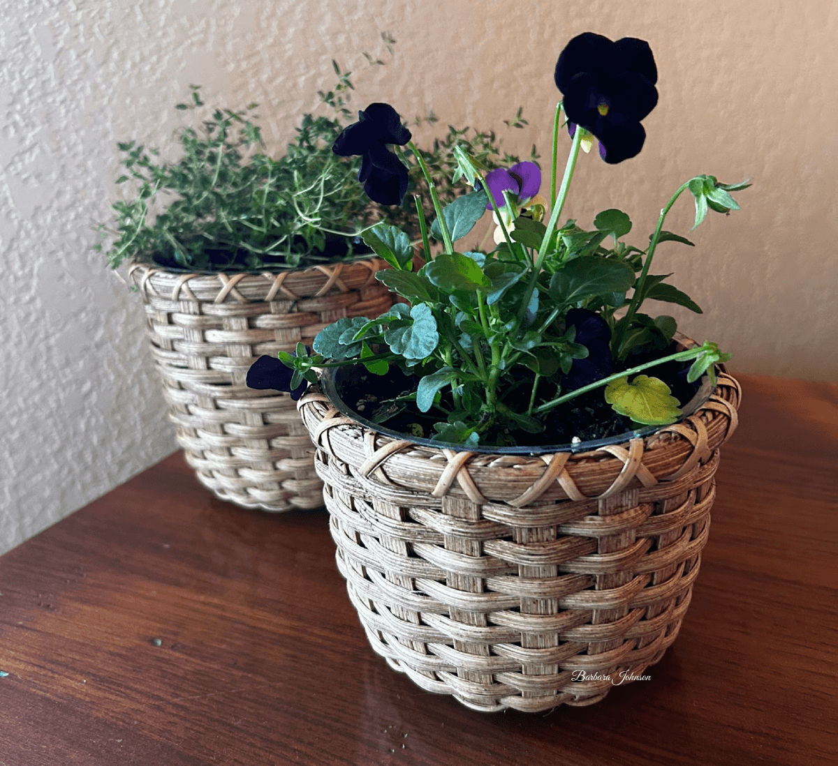 Smaller round basket with flowers in it.